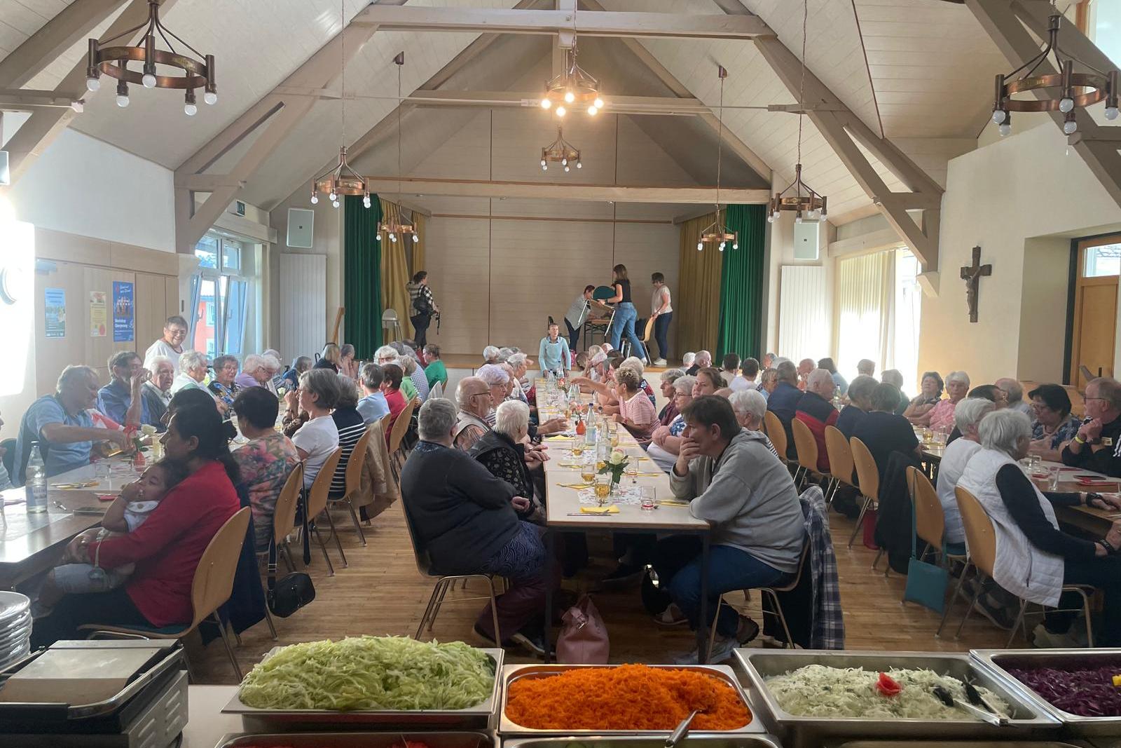 Im Waderner Pfarrheim sitzen die Menschen essen und trinken